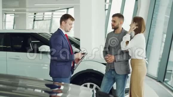 英俊的男性购车者正从友好的推销员那里得到关键的fob并与他握手然后亲吻和拥抱视频的预览图