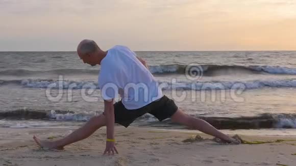 运动员早晨在海边沙滩上用波浪伸展身体视频的预览图