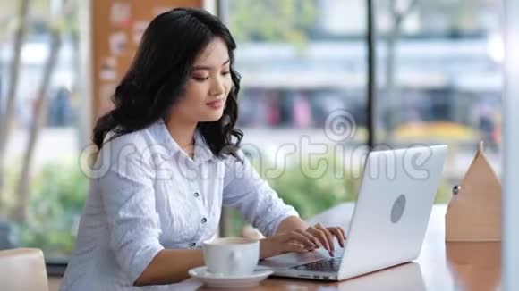 有吸引力的自由职业者亚洲女性用手提电脑写文字视频的预览图