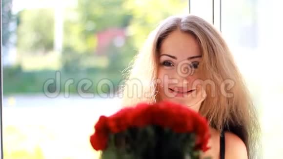 年轻女子得到一束红玫瑰生日庆祝活动礼品视频的预览图