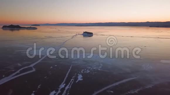 鸟瞰贝加尔湖冬天的湖有美丽的冰海岸和岛屿上的岩石俄罗斯冬季无人射击视频的预览图