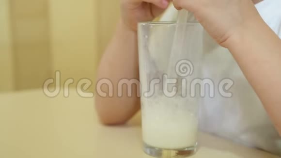 孩子慢慢地用吸管让泡泡进入奶昔一杯牛奶特写视频的预览图