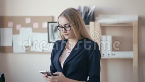 呼叫中心员工在办公室工作办公室里戴眼镜的金发少女女孩和她一起工作视频的预览图