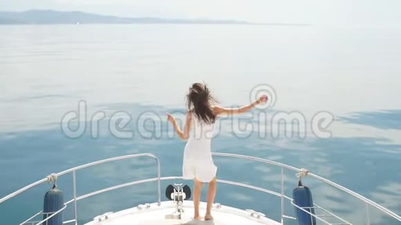 年轻女子穿着白色连衣裙享受阳光明媚的一天在浪漫的游艇旅行在一艘游艇上视频的预览图