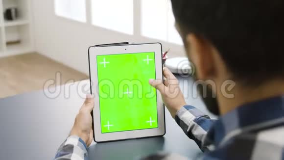 一名男子正在制作带有绿色屏幕的数字平板电脑视频的预览图