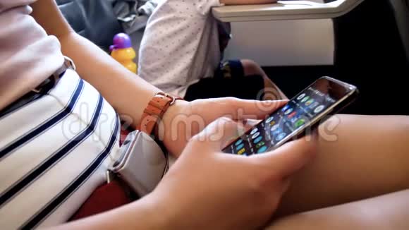 在飞机飞行过程中年轻女性通过智能手机无线上网的特写4k视频视频的预览图