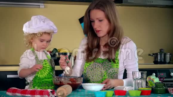 白人女人和可爱的女儿在厨房做饭家庭女孩玩得开心视频的预览图