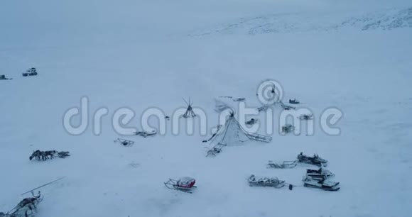 在北极生活在蒙古包里的人们用无人驾驶飞机录像乘坐雪橇的驯鹿在蒙古包周围驾驶着令人惊叹的视频的预览图