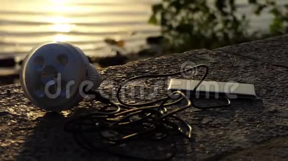 金属麦克风和手机躺在河岸上视频的预览图