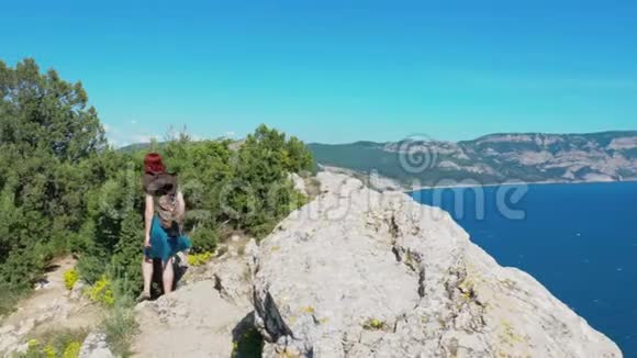 戴着牛仔帽背着背包的红发女孩走在山路上视频的预览图