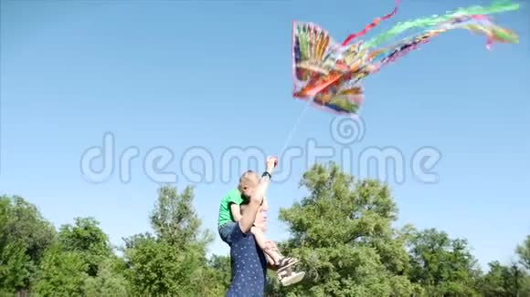 幸福的家庭和无忧无虑的童年幸福的家庭爸爸妈妈和儿子在大自然中行走发射了一条空中蛇视频的预览图