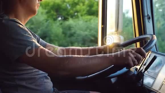在阳光明媚的夏日男人把手放在方向盘上在乡间小路上开着一辆卡车高加索人的进步视频的预览图