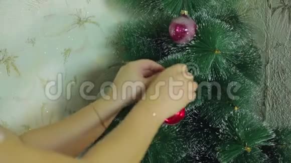 女人手用节日球装饰圣诞树视频的预览图