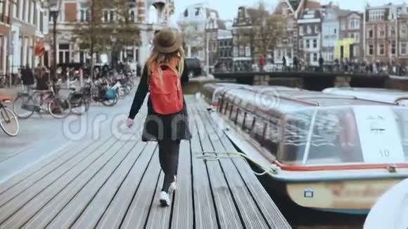 年轻的欧洲女士走在电话里乘坐小船自由轻松地沿着木河堤散步4K视频的预览图