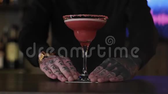 酒保嬉皮士用杯子准备了一杯精致的草莓酒精鸡尾酒视频的预览图