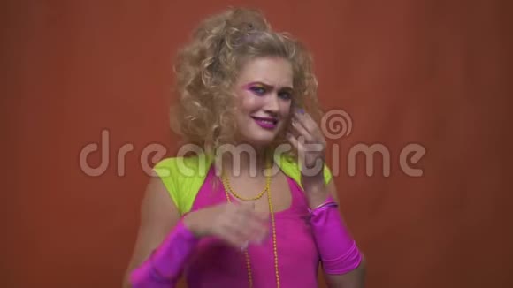 80年代派对上穿着粉色和绿色衣服动作缓慢的金发美女视频的预览图