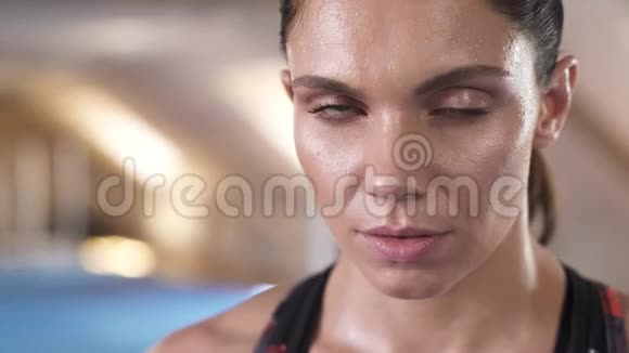 特写美女的肖像直视你的眼睛健身工作室的背景视频的预览图