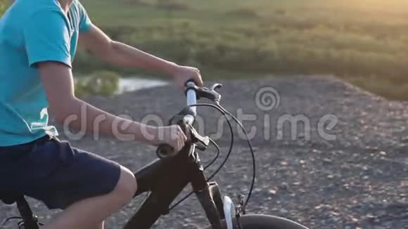 在山区骑黑色自行车的男孩的后视镜儿童自行车小男孩骑自行车在山上视频的预览图