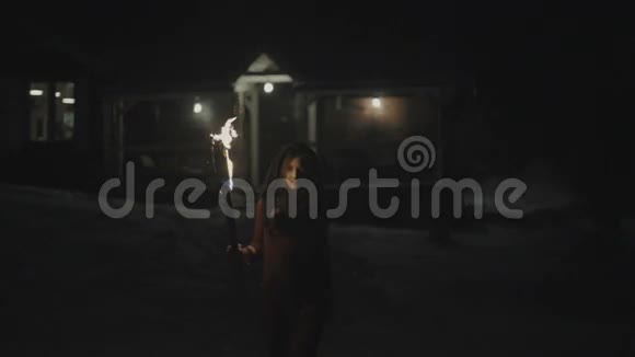 一个年轻神秘女人在黑暗中拿着火炬的肖像视频的预览图
