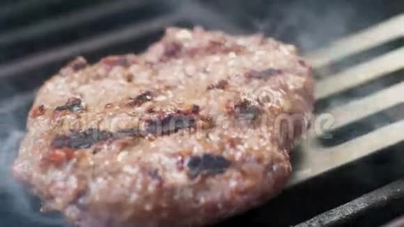 厨师把肉翻到烤架上烤汉堡视频的预览图