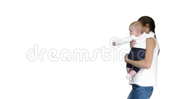 年轻的母亲在白色背景上抱着她的孩子时做了一个注意的手势视频的预览图