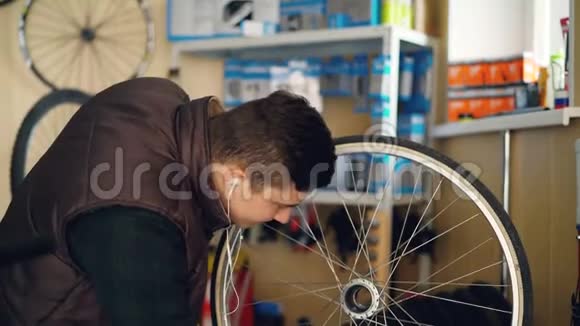 年轻的维修工正在擦洗自行车车轮上的污垢用一块布料清洗然后用视频的预览图