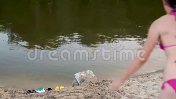 夏天穿着泳衣的美丽苗条的女孩潜入河里海滩季节视频的预览图