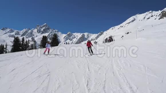 两名滑雪女滑雪者在山坡上一起滑雪视频的预览图