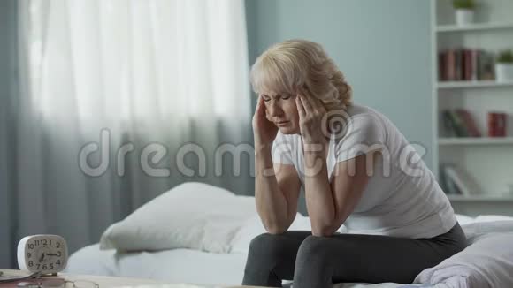 老年妇女坐在床上头痛得厉害健康问题视频的预览图