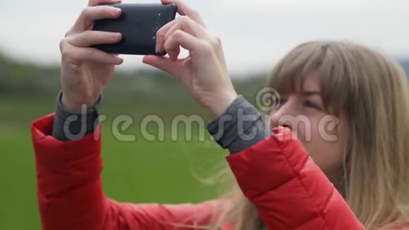 年轻女子为爱尔兰典型的绿色景观拍照视频的预览图