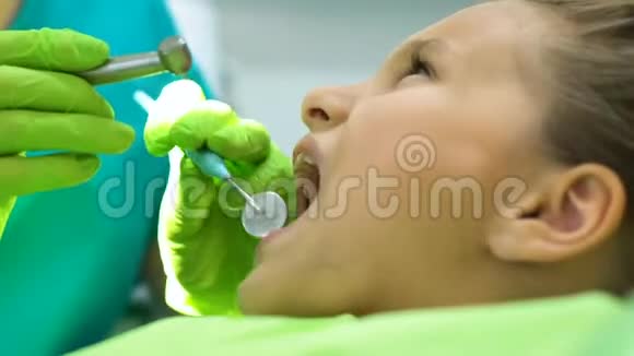 儿童牙医给小女孩钻牙及时龋齿治疗视频的预览图