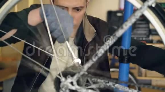 专业的自行车修理工正忙着固定自行车车轮的转动机构并用扳手进行调整金属轮视频的预览图