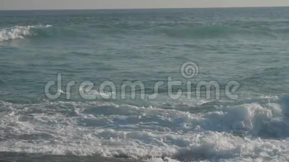 巨大的海浪在海滩上翻滚蓝天慢动作视频的预览图