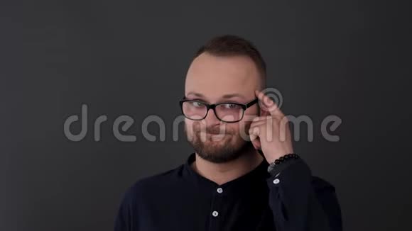 一个戴眼镜的留胡子的年轻人工作室拍摄的男性扭曲他的手指在寺庙带头的鼻子谴责视频的预览图
