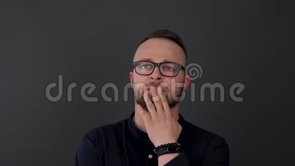 一个戴眼镜的留胡子的年轻人工作室拍摄的男性思考什么然后挥动他的手和交谈视频的预览图