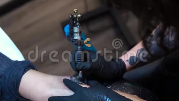 纹身大师女孩在白种人女人手臂上做纹身视频视频的预览图