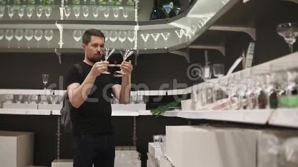 在餐具店里胡子男正在找两个玻璃杯喝精神饮料视频的预览图