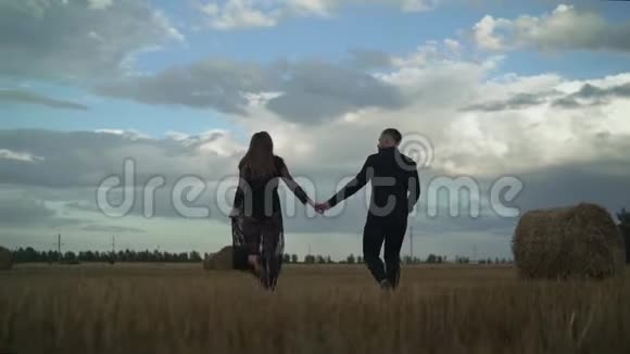 一对幸福的夫妇在田野日落的背景下玩得很开心英俊的白人穿着白衬衫温柔地拥抱着视频的预览图