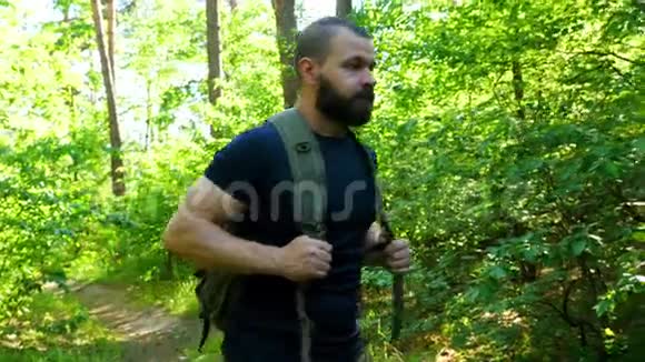 留着胡子的嬉皮士走在森林路上冒险远足假日视频的预览图