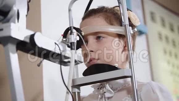 女孩子在眼科检查中冷静地坐着头固定视频的预览图