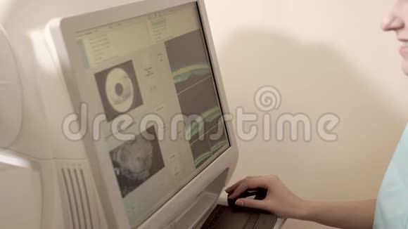 医生坐在视网膜断层扫描设备后面视频的预览图