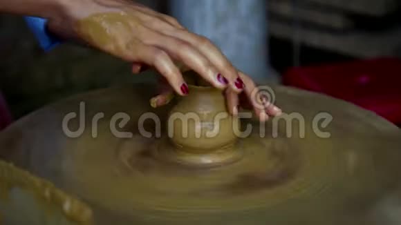 女士的双手在旋转的陶轮上制作陶罐颈视频的预览图