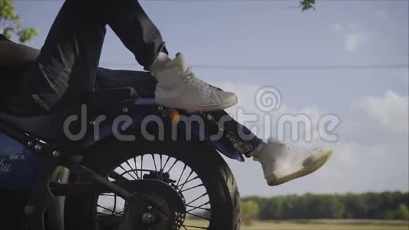 白色运动鞋和摩托车轮摩托车背景上的白色运动鞋视频的预览图
