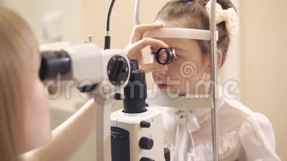 女眼科医生用生物显微镜检查小女孩视频的预览图