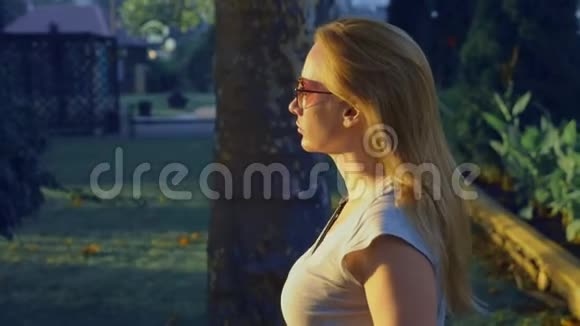 一个年轻的蓝眼睛女人站在商场的公园里的肖像4慢镜头拍摄视频的预览图