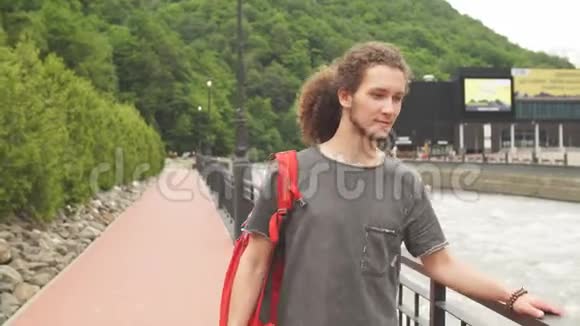 带红色背包的男士旅行者在户外放松背景是岩石山视频的预览图