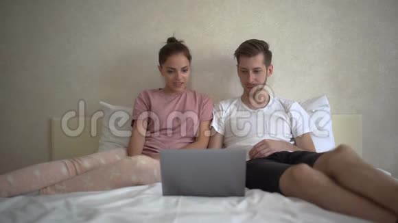 一对夫妇用电脑看有趣的电影视频的预览图