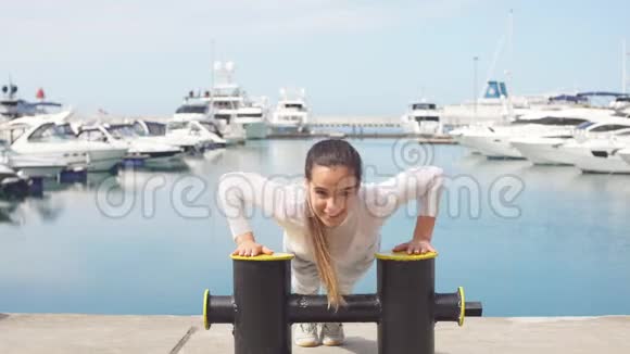 运动的女人在户外训练在海洋码头做交叉健身运动视频的预览图
