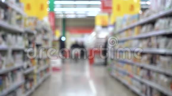 有购物车的人人们在超市购物离焦模糊的背景视频的预览图