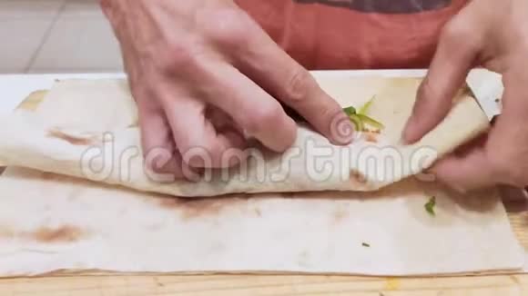 特写镜头男人手在准备沙瓦玛用肉蔬菜和酸煮美味沙玛的过程视频的预览图